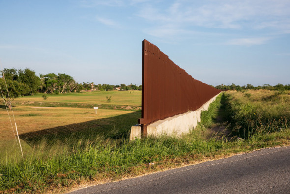 A break in the border fence leaves room for a road to pass through in Brownsville, Texas