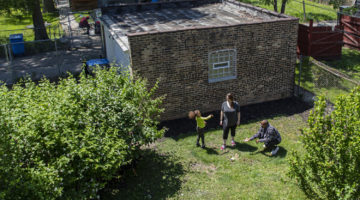 Richard and Sara Thomas and their daughter, Sofy, 4, play with their dog Brooklyn in their backyard on June 1, 2021 near the garage where they plan to build an additional dwelling unit behind their two-flat home in the West Woodlawn neighborhood.